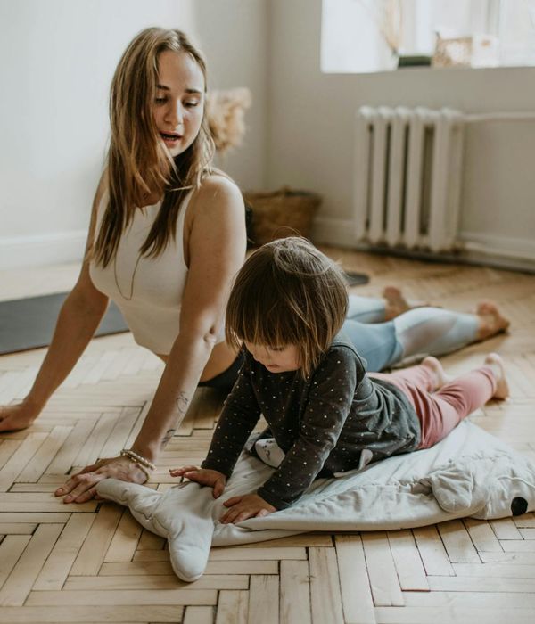 Woman performing a gentle yoga stretch in a calm, dark room.